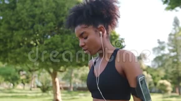 非裔美国年轻女子运动员从可重复使用的瓶子中喝水晨练后呼吸急促视频的预览图