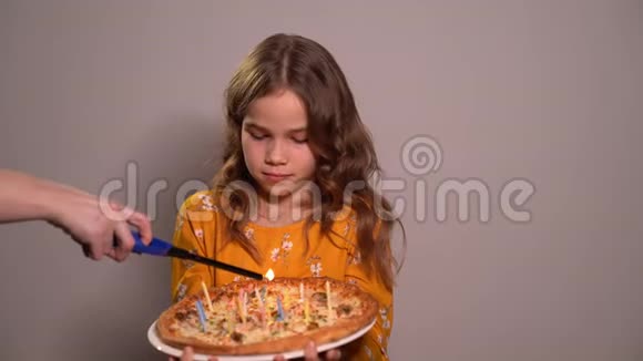 一个小女孩的生日在披萨上点蜡烛视频的预览图