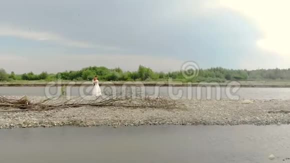 鸟瞰河岸上的新婚夫妇站着欣赏自己河边的新婚夫妇站在视频的预览图