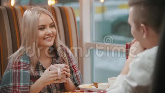 一个年轻的女人在咖啡馆里喝咖啡和男朋友聊天视频的预览图