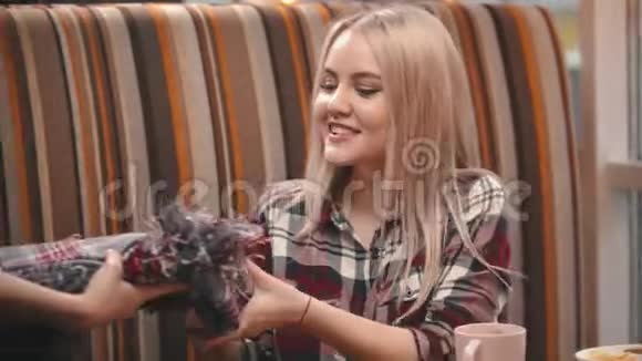 侍者把毯子给咖啡馆里的一个年轻女子视频的预览图