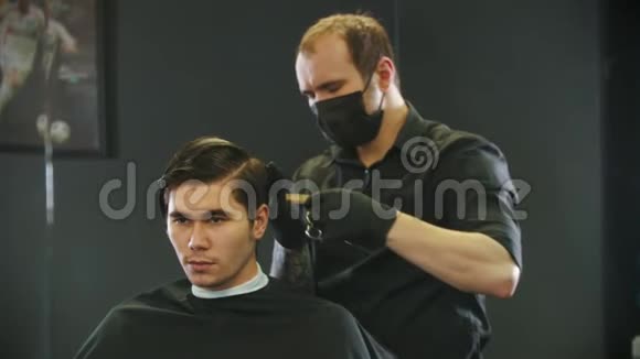 理发师在剪年轻人的客户湿发在带子镜子反射视频的预览图