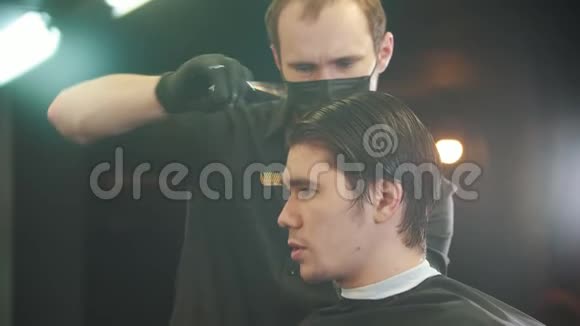 在理发店剪发的黑发帅哥视频的预览图