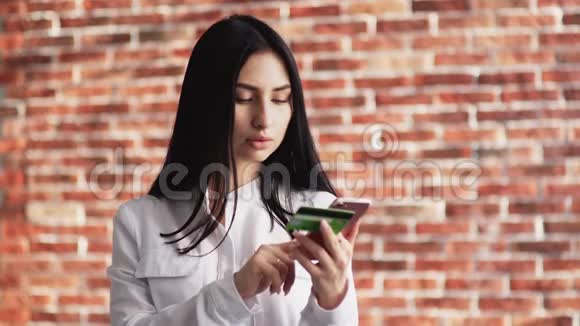 女孩在网上输入银行卡的数据购买购物狂的女人在网上商店买东西视频的预览图