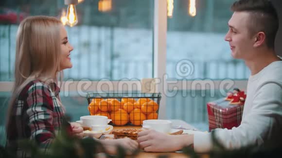 一对夫妇在咖啡馆吃华夫饼一个男人给他的女朋友圣诞礼物视频的预览图