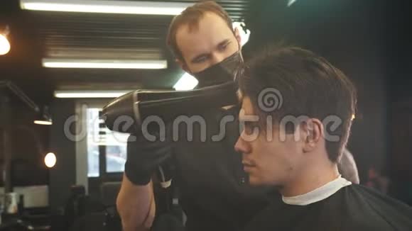 一位年轻英俊的男子接受了纹身男理发师的服务理发后把头发擦干视频的预览图