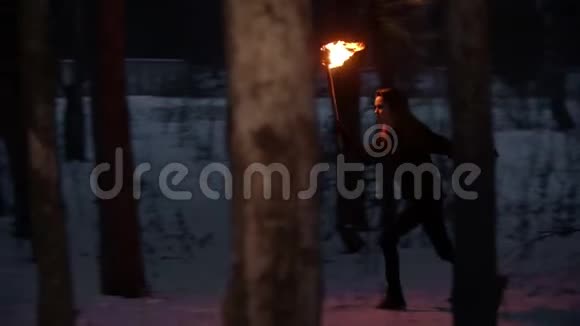 一个年轻的女人手里拿着火炬从森林里跑出来视频的预览图