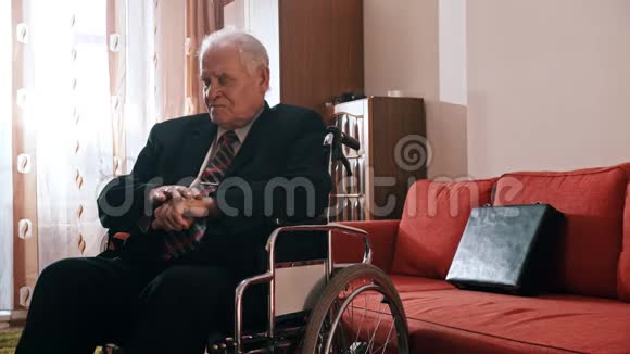 年迈的祖父祖父坐在轮椅上搓手视频的预览图