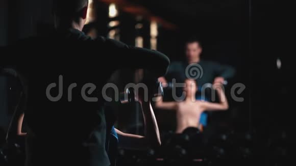 健身女子健身教练在健身房用哑铃锻炼身体视频的预览图