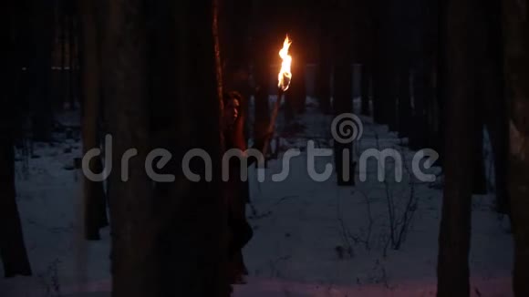 年轻的迷路女子带着火炬在森林中漫步视频的预览图