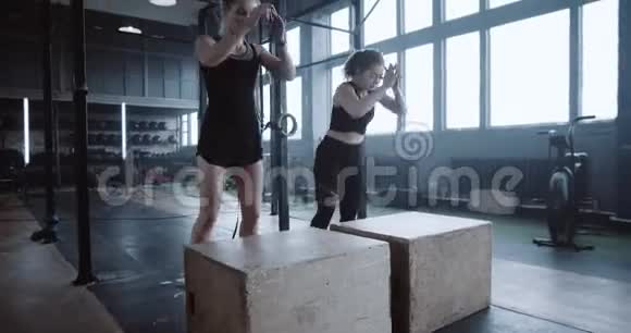 快乐的白种人年轻女性正在和私人女教练一起锻炼在大型健身房中跳着慢动作视频的预览图