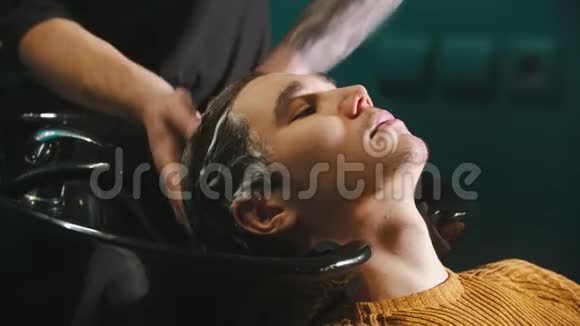 理发店里用洗发水洗头的年轻人视频的预览图