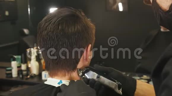 理发师用理发器把头发磨在客户身上视频的预览图