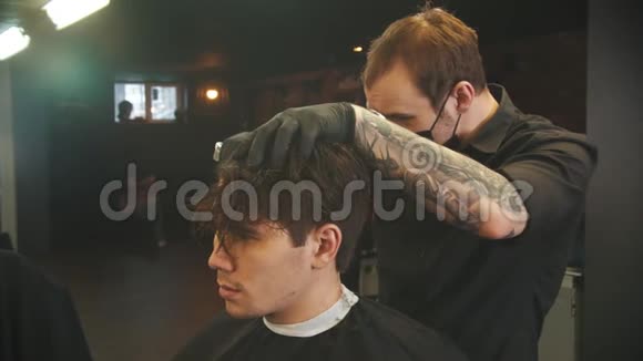 纹身的理发师用剪发器剪下客户的头发视频的预览图