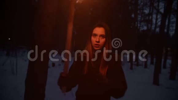 带着火炬的年轻女子试图逃离危险在森林里环顾四周视频的预览图