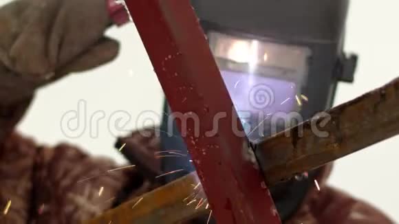 一个戴防护面罩的人正在焊接金属结构从结构侧面看视频的预览图
