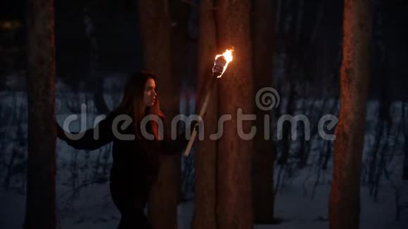 年轻的迷路女子带着火把走在森林里视频的预览图