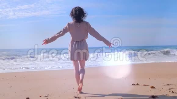 女人用手臂在海滩上行走镜头闪光效果视频的预览图