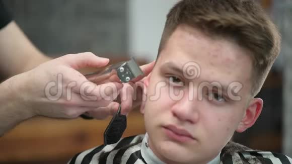 年轻人在理发店理发主裁剪头发的特写视频的预览图
