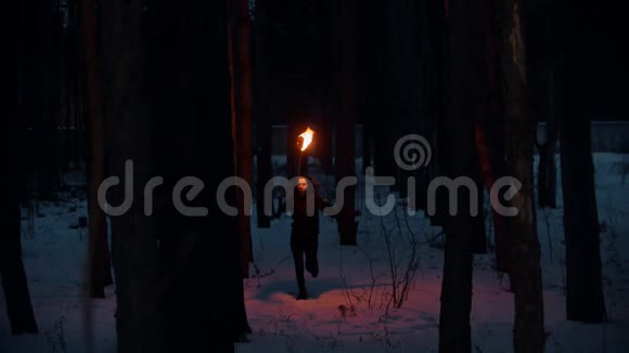 夜冬森林里火炬传递的年轻女子视频的预览图