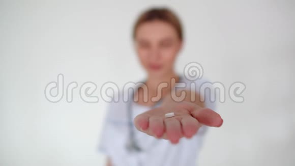 一个拿着药丸的女人的手从镜头里消失了女医生手臂上长着一颗药丸把它捏成拳头然后视频的预览图
