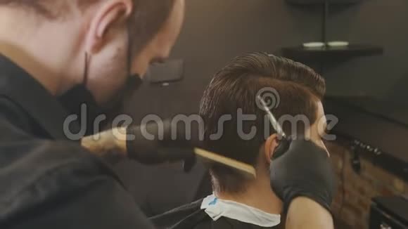 理发师用剪刀和刷子客户的头发扎在带子上视频的预览图