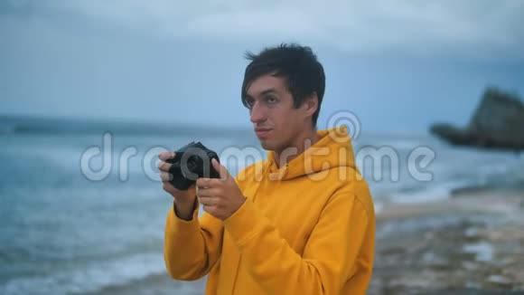 年轻的冒险摄影师在美丽的热带海滩拍照视频的预览图