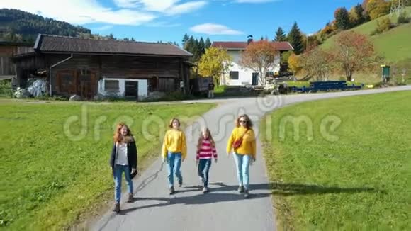 一群女孩在绿色田野之间的道路上行走视频的预览图