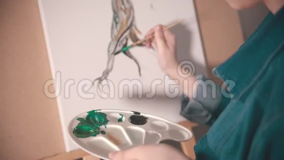 一位年轻的女画家用深色画树干视频的预览图