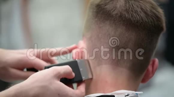 年轻人在理发店理发主裁剪头发的特写视频的预览图