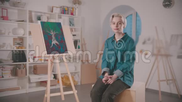 画完后一位年轻的女艺术家坐在艺术工作室里视频的预览图