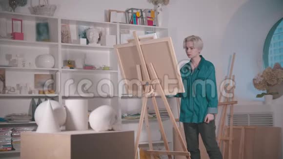 一位年轻的女艺术家在艺术工作室的桌子上画一个头骨和其他图形视频的预览图