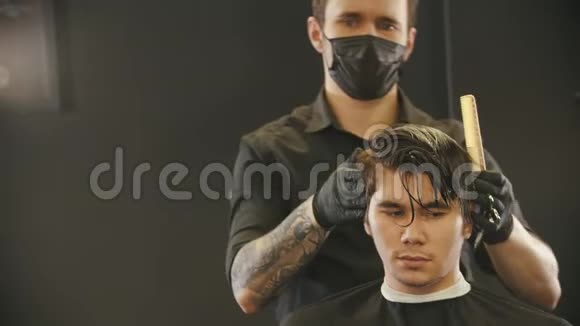 理发师刷刷客户湿的头发反射在镜子里视频的预览图