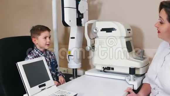 眼科医生治疗成熟的女医生与小男孩交谈视频的预览图