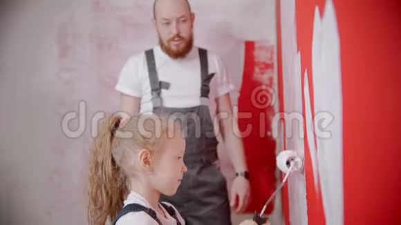 爸爸教他的小女儿如何正确地粉刷墙壁视频的预览图