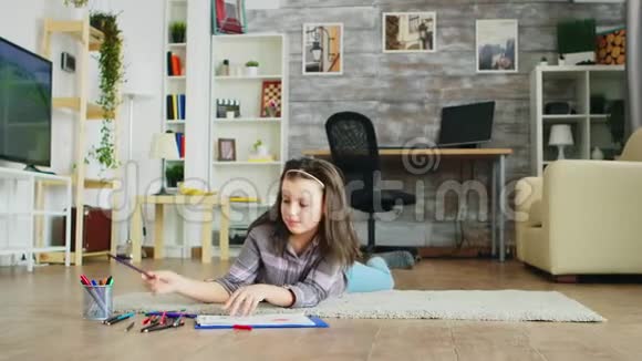 快乐的小女孩躺在客厅的地板上视频的预览图