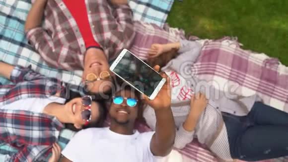 一群年轻的学生躺在草地上自拍视频的预览图