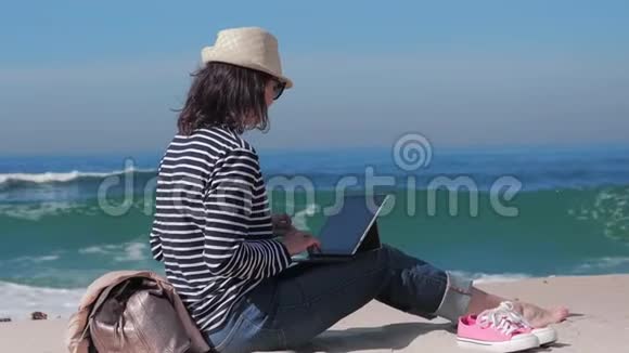 女人在沙滩上网上聊天在外面工作视频的预览图