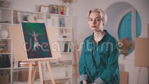 一位年轻的女艺术家短发留在艺术工作室视频的预览图