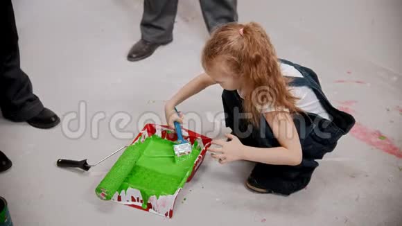 女儿正在盘子里用刷子刷绿色油漆视频的预览图