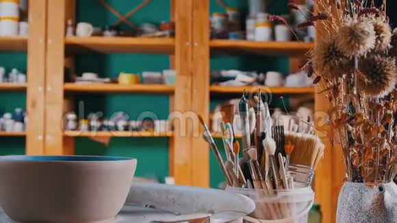陶器车间制作陶制碗碟的不同工具一个人走到架子上从架子上拿出油漆视频的预览图