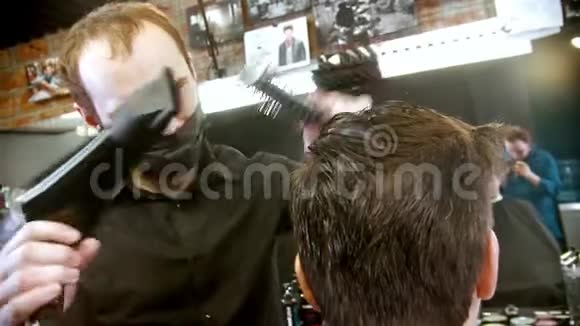 戴黑色面具的理发师用吹风机和刷子给客户头发做造型视频的预览图