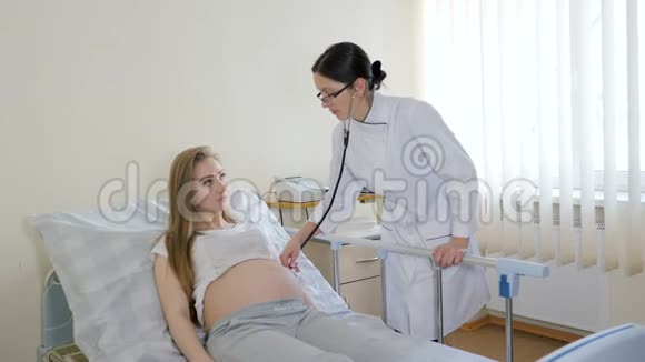 在诊所检查孕妇的女医生的特写视频的预览图