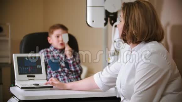 眼科诊所的一种治疗方法一个小男孩用眼罩遮住他的眼睛并从上面的投影视频的预览图