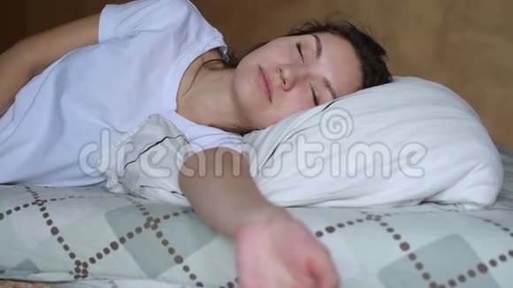 躺在床上的年轻女子睁开眼睛意识到她睡过头了视频的预览图