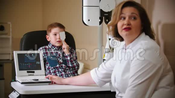 眼科诊所的一种治疗方法一个小男孩用眼罩遮住他的眼睛并从上面的投影视频的预览图