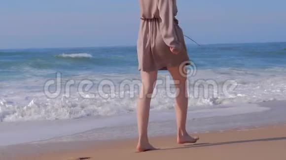 在沙滩上散步的女人海浪视频的预览图