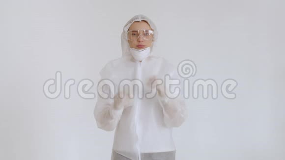 一个女孩穿着一次性化学防护服和眼镜调整她的呼吸器女医生戴上呼吸器视频的预览图