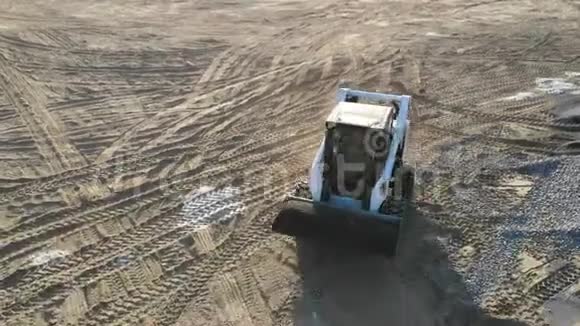 空中观景小挖掘机搬运一小山瓦砾从一架载有碎石的挖掘机上看到的视频的预览图