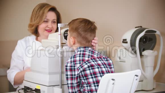 一个在眼科诊所接受治疗的男孩一位女医生通过检查一个特别的大男孩的视力视频的预览图